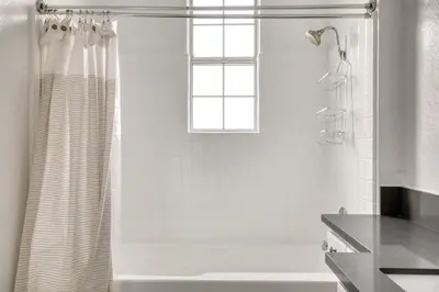 a white bathroom with a shower curtain and a window at Beverly Hills 2BR near the Grove Rodeo Drive LAX-866 in Los Angeles