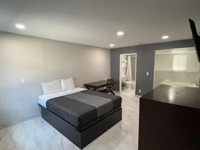 a bedroom with a bed and a bathroom with a tub at Goldstar Inn in Los Angeles