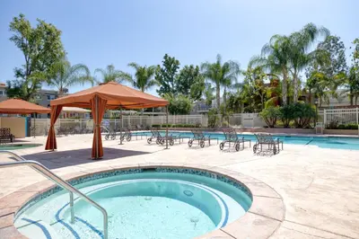 a hot tub with tables and chairs and an umbrella at Woodland Hills 2BR w Pool Gym nr Warner Center LAX-699 in Los Angeles