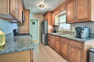 a kitchen with wooden cabinets and granite counter tops at San Gabriel Valley Hideaway! Family Home with Patio in Temple City