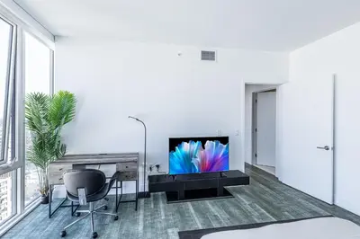 a living room with a television and a table and chairs at Top Floor High Rise 3 Bed DTLA Skyscraper Penthouse in Los Angeles