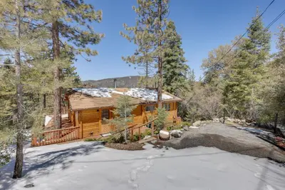 a log cabin in the woods in the snow at Pine Mountain Club Cabin Rental with Pool Access! in Pine Mountain Club