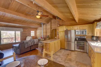 a kitchen and living room in a log cabin at Pine Mountain Club Cabin Rental with Pool Access! in Pine Mountain Club