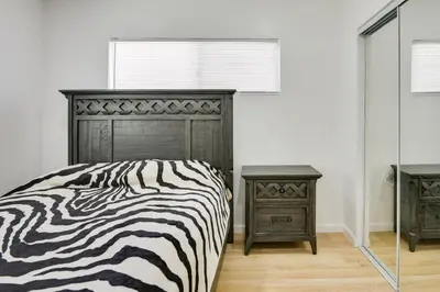 a bedroom with a zebra print bed and two night stands at Home Between Los Angeles and Disney! Patio, Yard in Pico Rivera