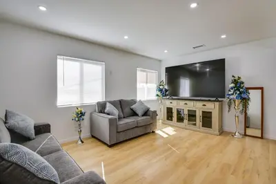 a living room with a couch and a large screen tv at Home Between Los Angeles and Disney! Patio, Yard in Pico Rivera