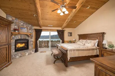 a bedroom with a bed and a fireplace at Big Bear Village View Haus is a large pet and kid friendly chalet with hot tub located a short walk to village in Big Bear Lake