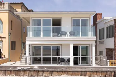 a large white house with chairs on the balcony at 5609 East Seaside Walk in Long Beach