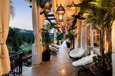 a building with a balcony with white chairs and plants at Bel Air Luxury Villa 6 bedrooms entire house Los Angeles in Los Angeles