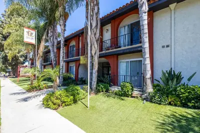 a building with palm trees next to a sidewalk at Sherman Oaks 1BR w Pool Gym BBQ nr TJ WF LAX-487 in Los Angeles
