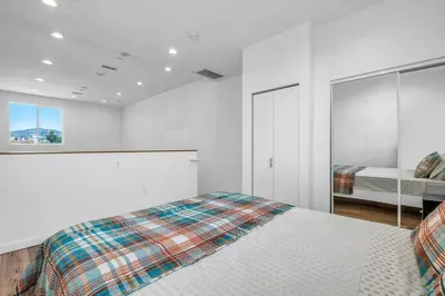 a white bedroom with a bed and a window at Cozy Oasis near Griffith Observatory in Los Angeles