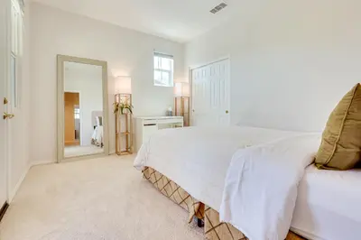 a white bedroom with a bed and a mirror at Family-Friendly Camarillo Home with Access to Pools! in Camarillo