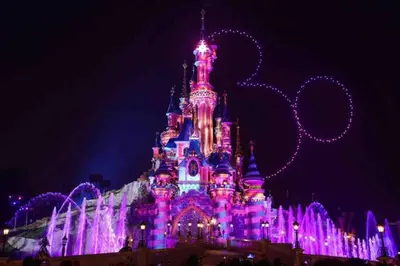 a disney castle lit up in purple at night at Beautiful home near Disneyland. Entire place! in Orange