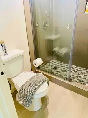 a bathroom with a toilet and a glass shower at Beautiful home near Disneyland. Entire place! in Orange
