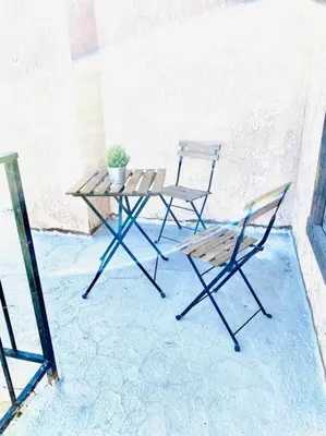 two chairs and a table and a potted plant on a patio at Beautiful home near Disneyland. Entire place! in Orange
