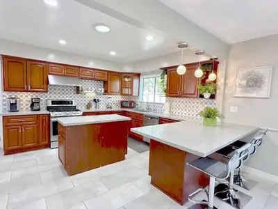 a large kitchen with wooden cabinets and a large island at Orchard Villa Disneyland 5 Bedroom Pool Home Spa in Anaheim