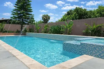 a swimming pool in a backyard with a blue tiled at Cypress Villa Disneyland 8 Bedroom 4Bath Pool Game in Anaheim