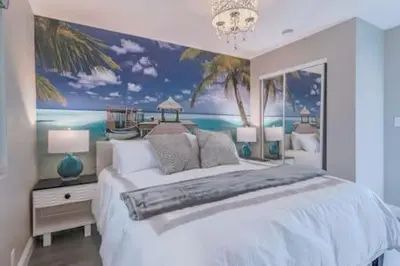a bedroom with a large bed with a painting on the wall at Cypress Villa Disneyland 8 Bedroom 4Bath Pool Game in Anaheim