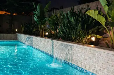 a pool with two waterfalls in a brick wall at Cypress Villa Disneyland 8 Bedroom 4Bath Pool Game in Anaheim