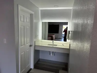 a bathroom with a sink and a mirror at Rancho Motel - Ontario Airport in Ontario