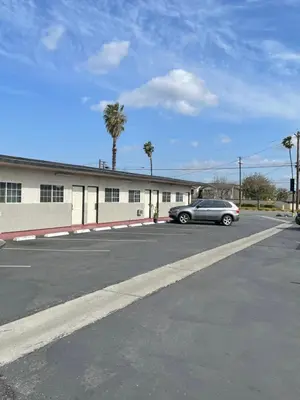 a car parked in a parking lot in front of a building at Rancho Motel - Ontario Airport in Ontario