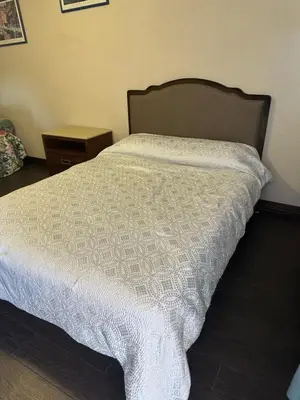 a bed with a white comforter in a bedroom at Rancho Motel - Ontario Airport in Ontario