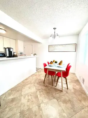 a kitchen with a table and two red chairs at Cozy house near Disney, Knott’s & Beach!! in Fullerton
