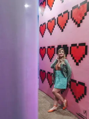 a woman standing in front of a wall with hearts at Audemar Boutique Hotel and Apartment Homes in Los Angeles