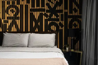 a bedroom with a bed with a black and yellow wall at Audemar Boutique Hotel and Apartment Homes in Los Angeles