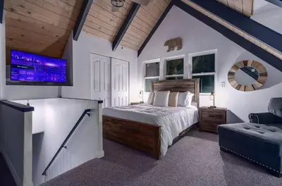 a bedroom with a bed and a tv in a room at Hot Tub-EV-Kid Friendly-Arcade Game-BBQ-Fire Pit in Lake Arrowhead