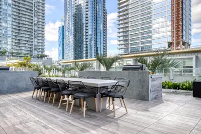 a table and chairs on a patio with tall buildings at Downtown 1BR w Pool Jacuzzi Gym nr 110 LAX-836 in Los Angeles