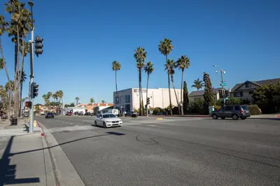 an intersection with a white car on a street with palm trees at Redondo Beach 1BR w Pool Gym WD nr Beach LAX-615 in Redondo Beach