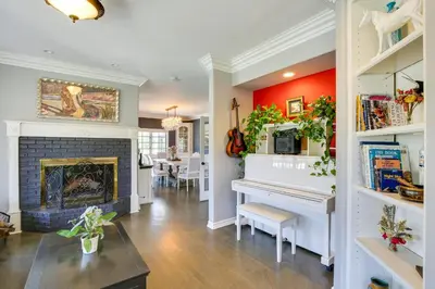 a living room with a fireplace and a white piano at Stunning Home in Orange County with Stables! in Orange
