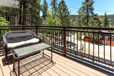 a bench sitting on the deck of a house at Circle Views by Big Bear Vacations Walk To Lake Boulder Bay Chalet in Big Bear Lake