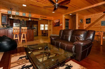 a living room with a leather couch and a table at Circle Views by Big Bear Vacations Walk To Lake Boulder Bay Chalet in Big Bear Lake