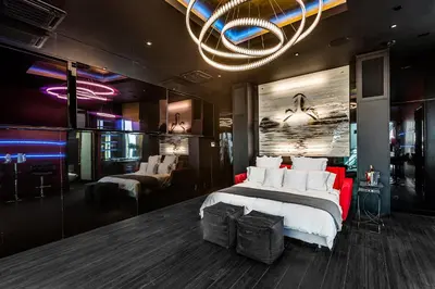 a bedroom with a bed and a couch and a chandelier at SW Beach Hotel in Hermosa Beach