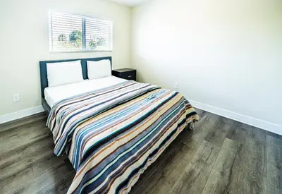 a bedroom with a bed with a striped blanket at Large Condo Sleeps 10 near Downtown Los Angeles in Los Angeles